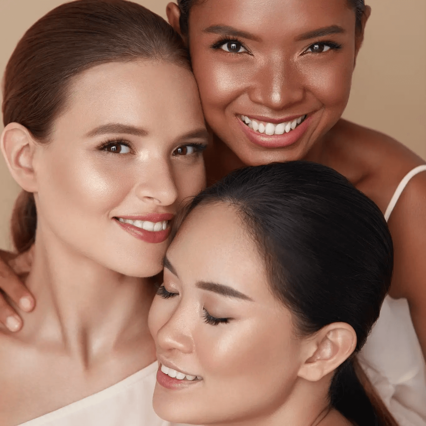 Three diverse women with different skin tones smiling confidently, showcasing natural beauty and radiant, healthy skin with Karin Herzog skincare.