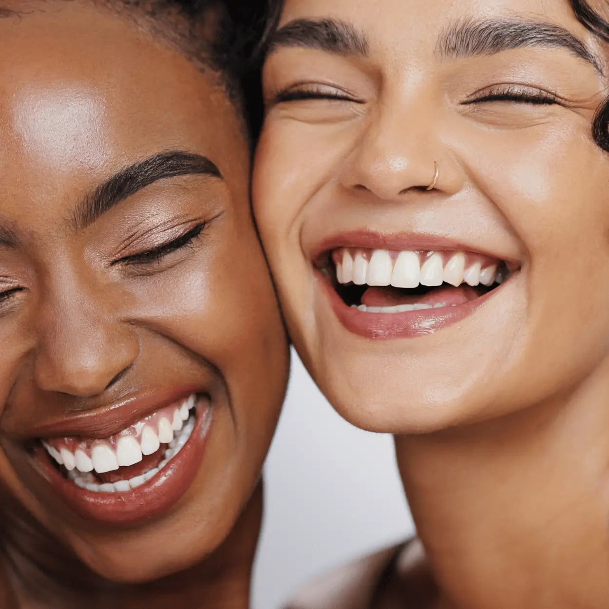 Two women smiling with radiant, glowing skin after using Karin Herzog Apricot Oil.