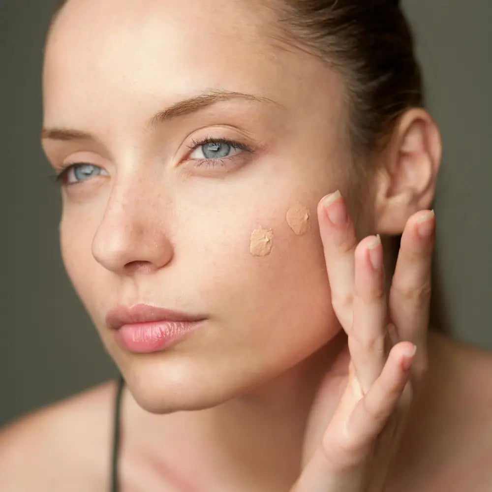 Model gently applying BB Cream Light to her face for a natural, glowing finish.