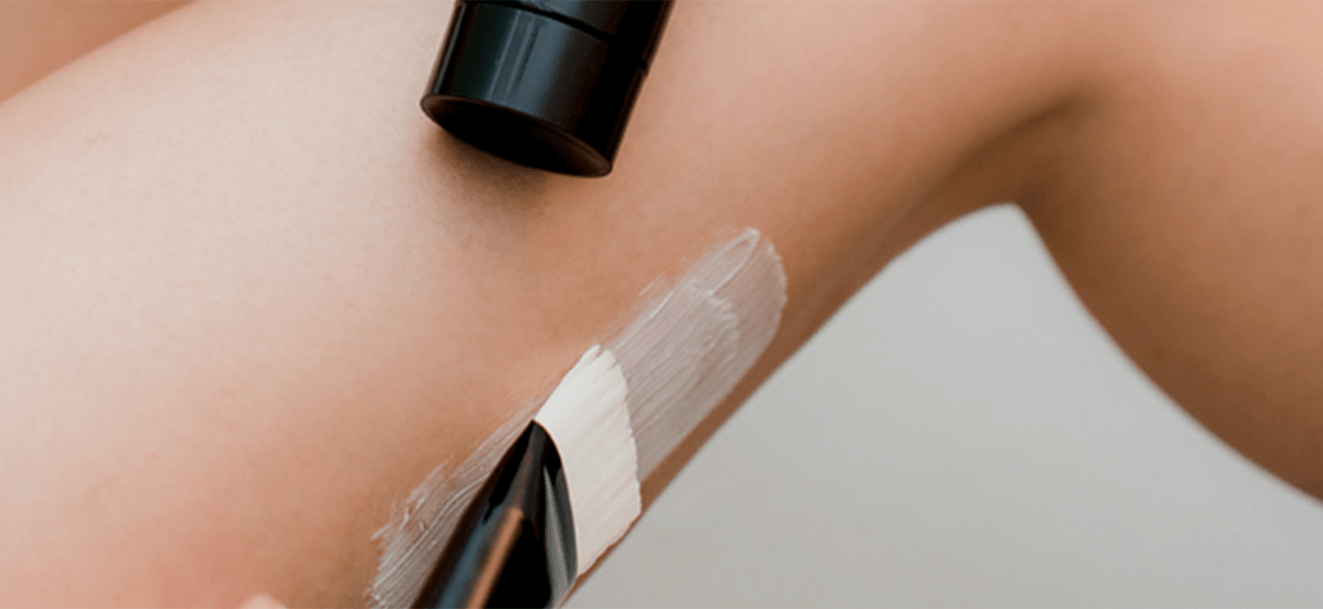 A woman’s leg being exfoliated with a Karin Herzog Body Brush while applying lotion, promoting smooth and revitalised skin.