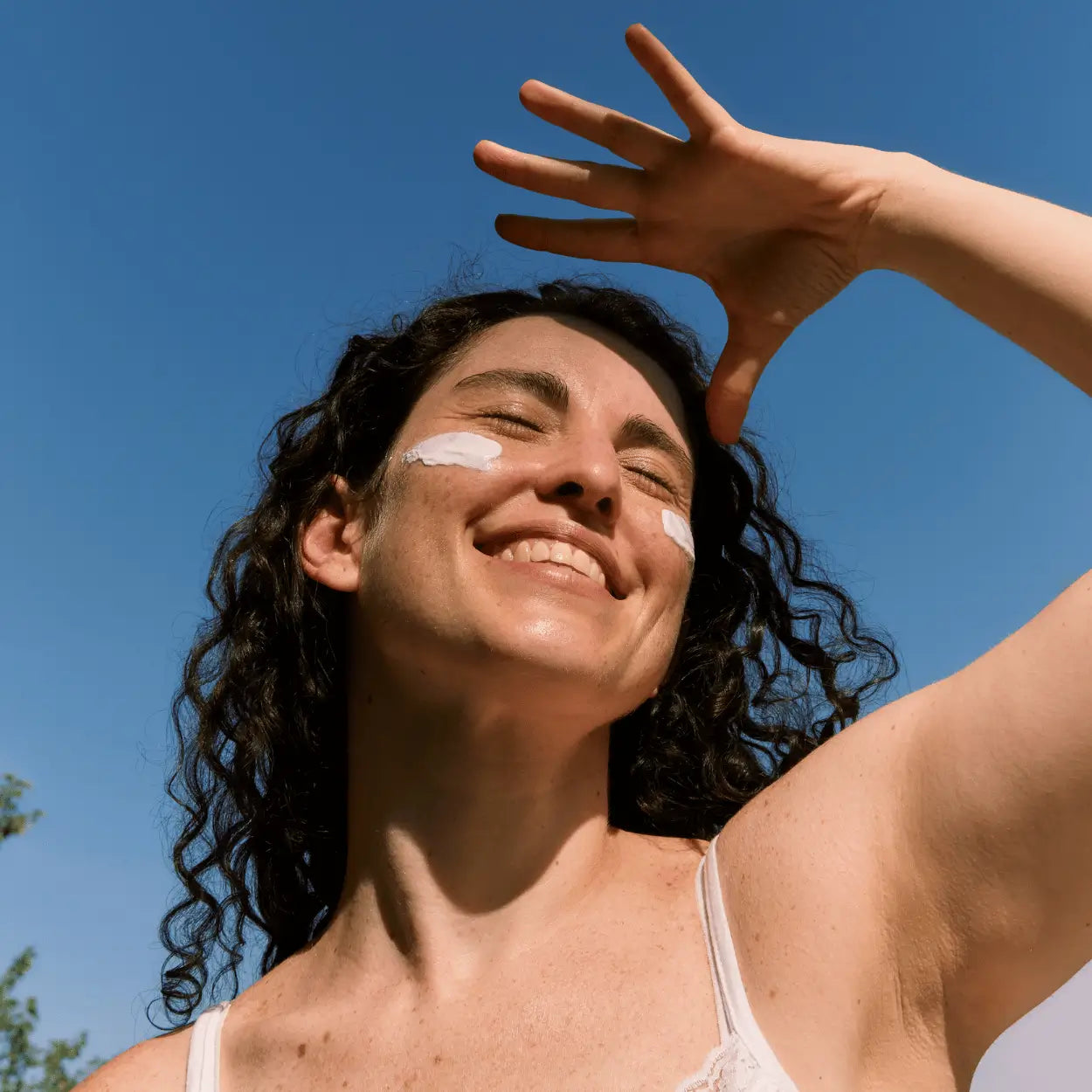 Woman smiling with Tonus B12 cream from Karin Herzog on her cheeks.